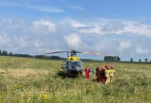 Śmigłowiec LPR na polu, obok strażacy