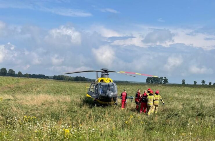 Śmigłowiec LPR na polu, obok strażacy